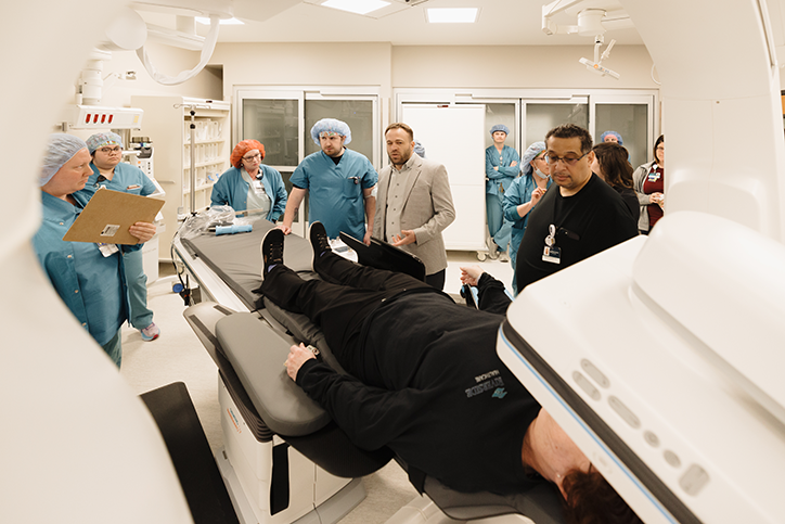 Doctors and healthcare professionals attend to a practice patient in a biplane imaging suite