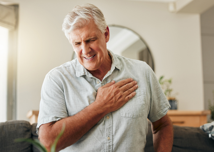 Man holds hand over chest in pain