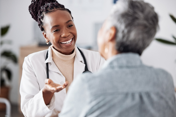 Doctor consulting a patient in meeting in hospital for healthcare feedback or support.