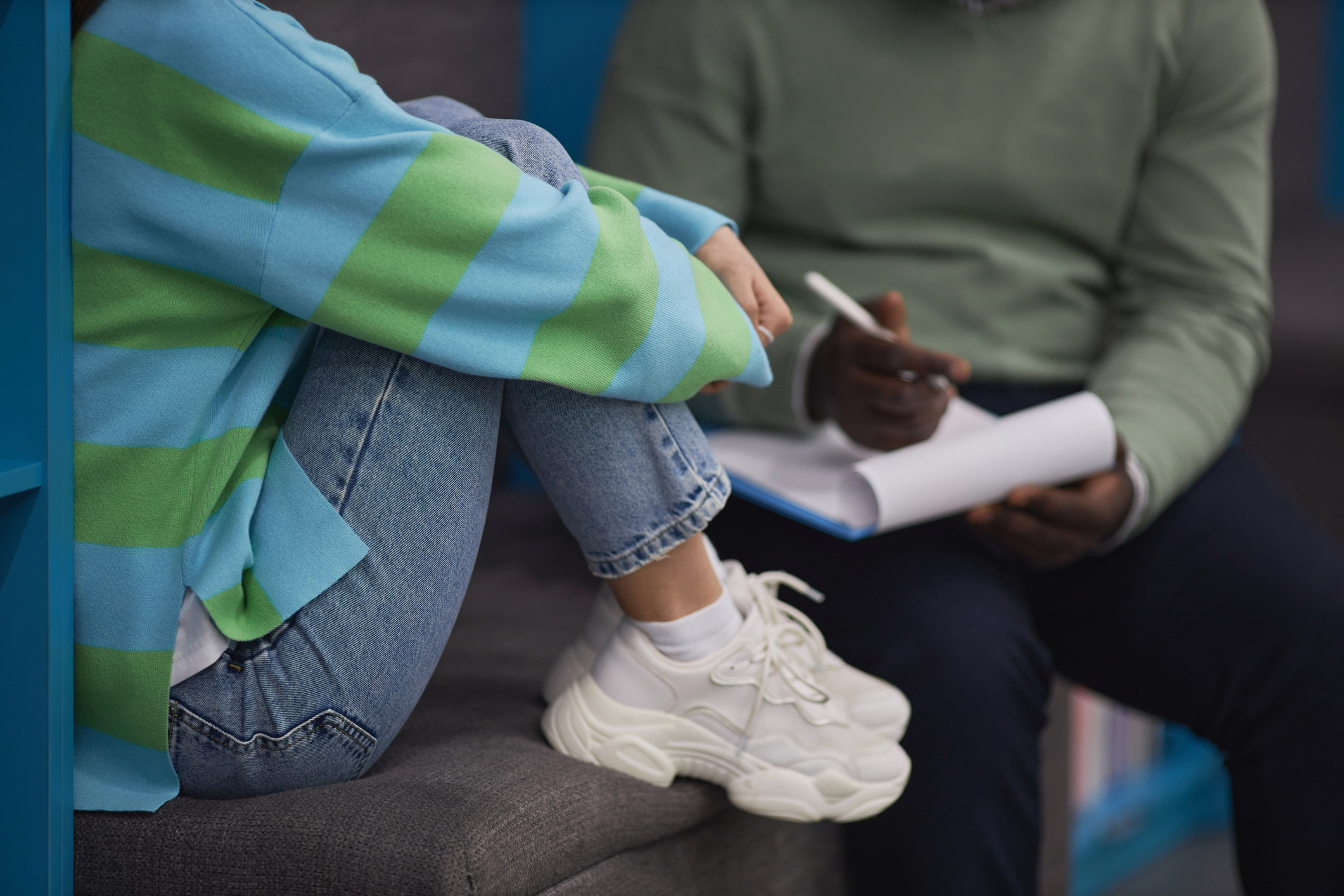 Counselor takes notes while speaking with student