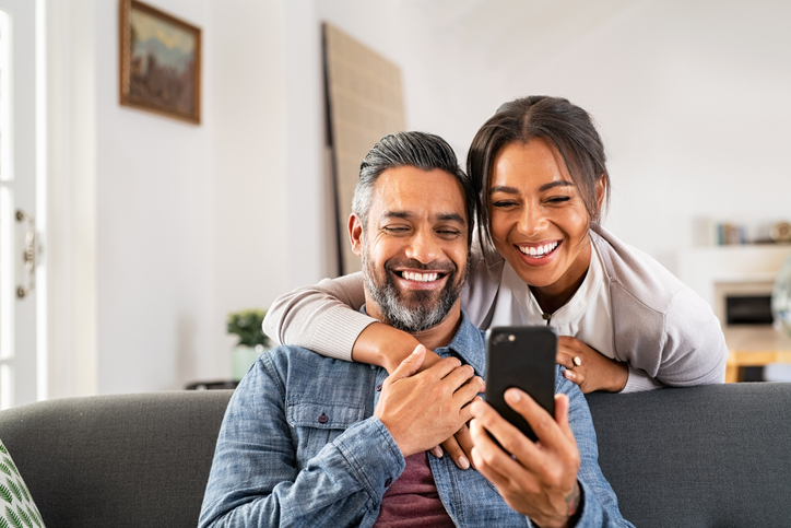 Man and woman in 40s sitting on couch