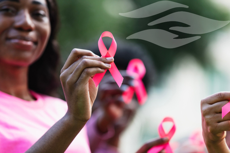 People holding pink ribbons for Breast Cancer Awareness Month.